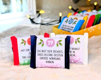 May include: Close-up of several wrapped chocolate bars with holiday-themed designs. One bar features the number 19 in a pink circle, with text in German. Other bars are visible in a yellow container, with various colors and designs.