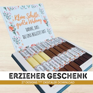 Puede incluir: Una caja de bombones con un diseño floral y texto en alemán. La caja contiene varias barritas de chocolate en tonos marrones y blancos. La parte superior de la caja tiene el texto "Kleine Schritte, große Wirkung" y "DANKE, DASS DU UNS BEGLEITET HAST".