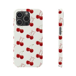 May include: White phone case with a pattern of red cherries with pink stems on a white background.