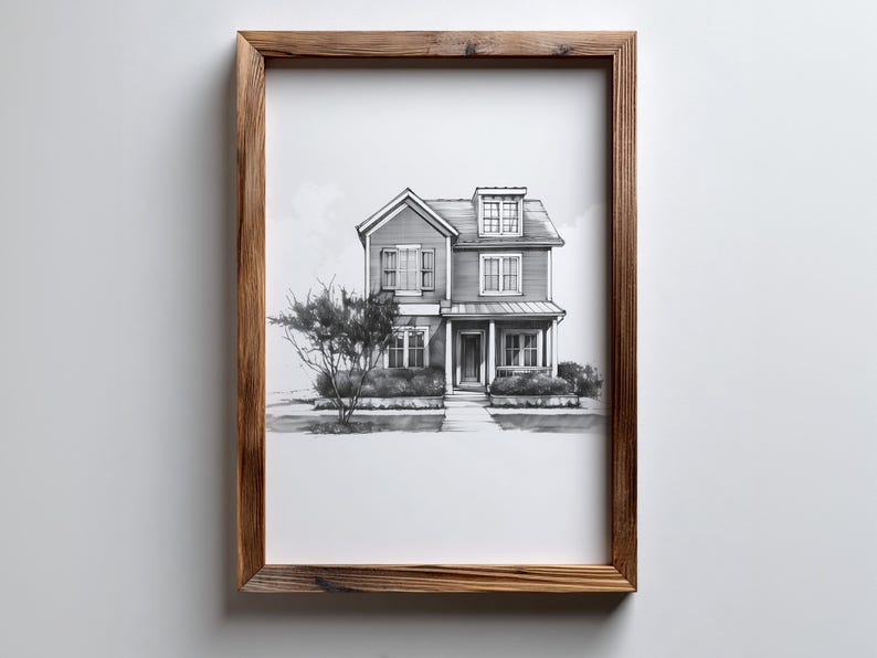 Może przedstawiać: Oprawiony czarno-biały szkic dwupiętrowego domu z werandą, lukarną i krajobrazem. Grafika znajduje się w rustykalnej brązowej drewnianej ramie, zamontowanej na białej ścianie. Dom ma wiele okien i drzwi wejściowe.