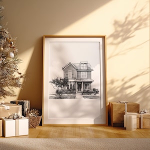 Może przedstawiać: Oprawiony czarno-biały szkic domu opiera się o ścianę, obok udekorowanej choinki i zapakowanych prezent&oacute;w. Grafika przedstawia dwupiętrowy dom z werandą i krajobrazem. Scena jest oświetlona naturalnym światłem.