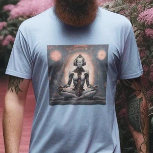 May include: A light blue t-shirt featuring a detailed graphic of a meditating figure with headphones. The person is walking in a pink-colored stream surrounded by pink flowers and green foliage. The person is wearing black pants.