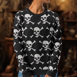 May include: Black sweater with a white skull and crossbones pattern.