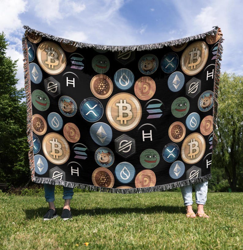 May include: A black woven throw blanket with a repeating pattern of cryptocurrency logos and internet meme characters. The logos include Bitcoin, Ethereum, Dogecoin, and Shiba Inu. The meme characters include Pepe the Frog and Doge.
