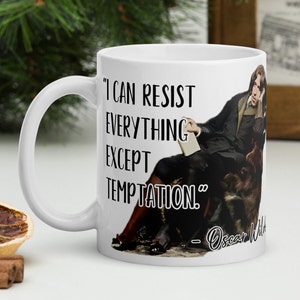 Puede incluir: Taza de cerámica blanca con una imagen en blanco y negro de Oscar Wilde y una cita que dice "Puedo resistir todo excepto la tentación." - Oscar Wilde.