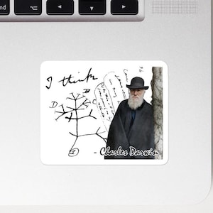 May include: A white sticker featuring a portrait of Charles Darwin, a tree diagram, and handwritten text. The text includes "I think" and "Charles Darwin". The image is on a laptop.