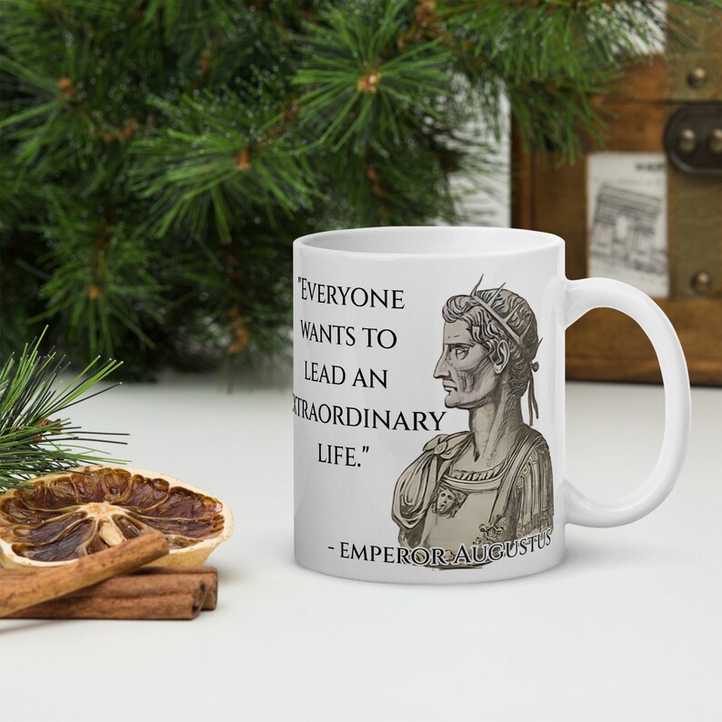 May include: White ceramic mug with a black and white image of Emperor Augustus and a quote that reads "Everyone wants to lead an extraordinary life." - Emperor Augustus