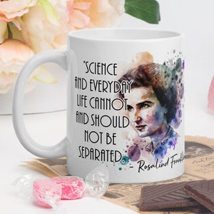 May include: White ceramic mug with a watercolour illustration of Rosalind Franklin. The mug features a quote from Rosalind Franklin: "Science and everyday life cannot and should not be separated."