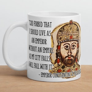 May include: White ceramic mug with a black and white quote from Emperor Constantine XI Palaiologos. The quote reads "God forbid that I should live as an emperor without an empire. As my city falls, I will fall with it." The mug features a colorful illustration of the emperor.