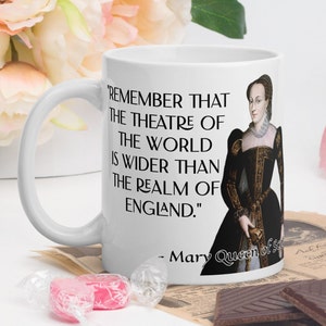 Può includere: Tazza in ceramica bianca con una citazione in nero di Maria, regina di Scozia: "Ricorda che il teatro del mondo è più ampio del regno d'Inghilterra."