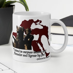 以下が含まれることがあります： 白地に赤と白の地図と馬に乗った男性のイラストが描かれた白いセラミックマグカップ。マグカップには、「私はカエサルとアレクサンドロスとクセルクセスをはるかに凌駕するつもりだ。」- メフメト2世の言葉が印刷されています。