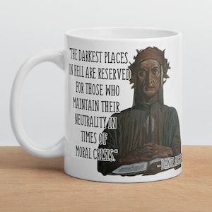 Puede incluir: Taza de cerámica blanca con una cita en negro de Dante Alighieri: "Los lugares más oscuros del infierno están reservados para aquellos que mantienen su neutralidad en tiempos de crisis moral." La cita está rodeada de una ilustración en blanco y negro de Dante Alighieri.