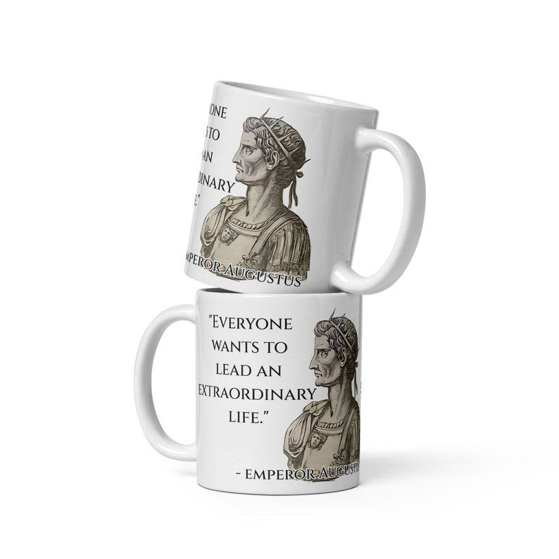 May include: Two white ceramic mugs with a black and white image of a man wearing a crown and armor. The top mug has the text "ONE TO AN ORDINARY LIFE" and "EMPEROR AUGUSTUS". The bottom mug has the text "EVERYONE WANTS TO LEAD AN EXTRAORDINARY LIFE." and "EMPEROR AUGUSTUS".