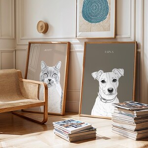 May include: Two framed pet portraits, one of a cat named "Messy" and the other of a dog named "Luna". The cat portrait is on a light tan background, and the dog portrait is on a gray background. The frames are wood.