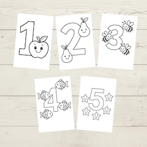 May include: Five white cards with numbers 1 through 5, each accompanied by a corresponding number of cute illustrations. The illustrations include an apple, pears, bees, fish, and stars. The cards are arranged on a light wood-grain surface.