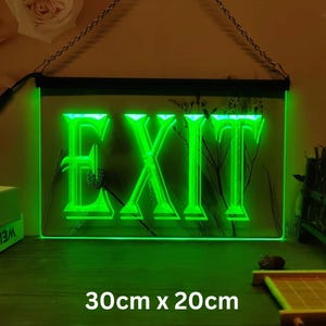 May include: Green neon sign with the word "EXIT" in a decorative font. The sign is 30 inches by 20 inches and is hanging from a chain.