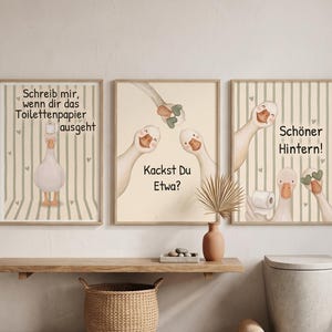 May include: Three framed wall art prints featuring cartoon geese on a striped background. The first print says "Schreib mir, wenn dir das Toilettenpapier ausgeht", the second "Kackst Du Etwa?", and the third "Schöner Hintern!" with illustrations of geese.