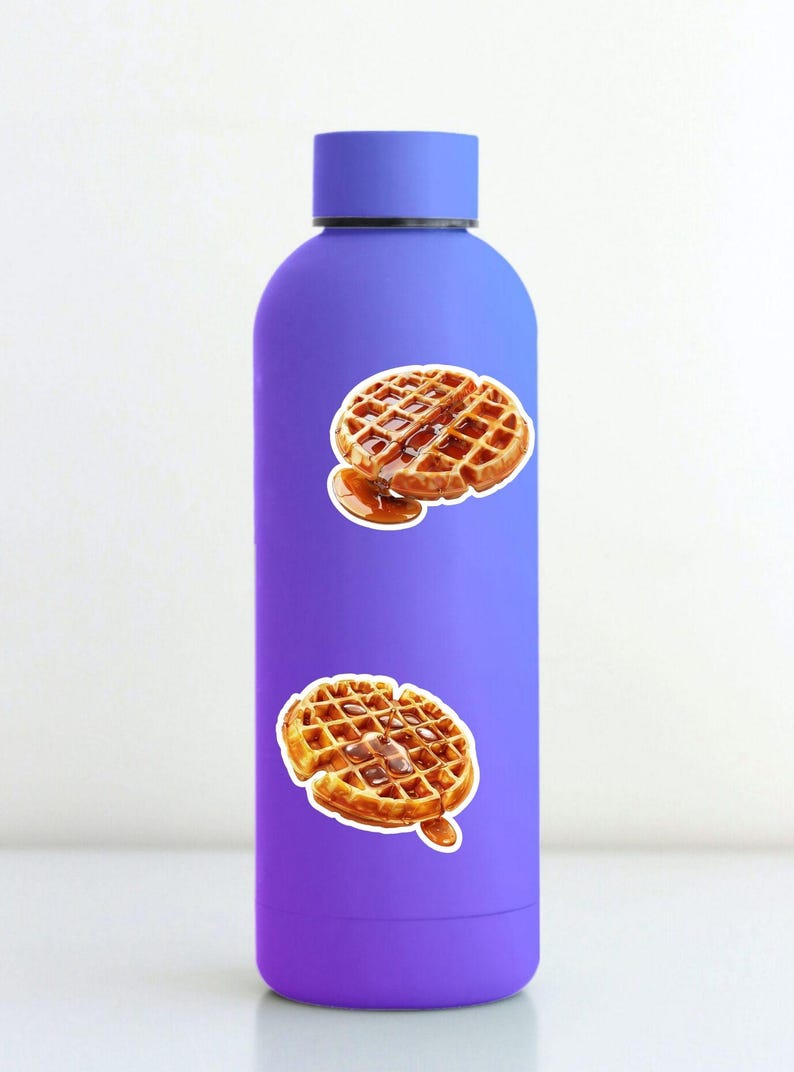 May include: A purple water bottle adorned with two waffle stickers. The waffles are golden brown with syrup. The bottle has a matching purple cap and a smooth finish. The stickers are placed on the front of the bottle.