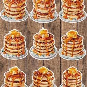 May include: Nine stickers featuring stacks of pancakes with butter and syrup. Each stack sits on a small plate with a blue and white floral design. The pancakes are golden brown, and the syrup is a rich amber color.