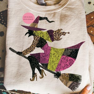 May include: A beige sweatshirt with a colourful witch design. The witch is riding a broom and is made up of patchwork patterns, including leopard print, pink, green, and black. The text "ORIGINAL DESIGNER" is in a pink circle.