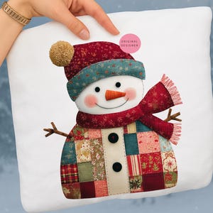 May include: A white square cushion with a charming snowman design. The snowman wears a red hat with a beige pom-pom, a red scarf, and a patchwork coat. It has a carrot nose, black button eyes, and a smiling mouth.