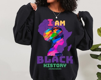 May include: Black sweatshirt with a colorful graphic of a woman's face and the text "I AM BLACK HISTORY" in purple.
