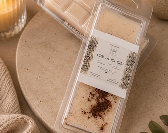 May include: Two wax melt packages in clear plastic containers. One contains six squares of light beige wax, the other has a rectangular shape with a brown powder sprinkled on top. The label reads "Science To Relax".