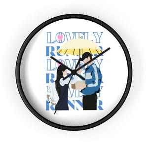 Puede incluir: Reloj de pared redondo con marco negro y esfera blanca. El reloj presenta un gráfico de dos personas bajo un paraguas amarillo, con las palabras "LOVELY RUNNER" en azul. Las manecillas del reloj son negras.