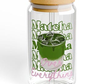 May include: A clear glass tumbler with a bamboo lid and straw. The tumbler features a green matcha drink graphic with ice cubes and the words "Matcha Over Everything" in green and pink.