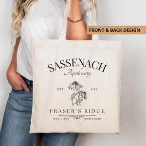 Puede incluir: Bolso tote de color crema con el texto "Sassenach Apothecary" y "Fraser's Ridge" en negro. El bolso presenta una ilustración botánica y las palabras "Medicinal Herbs & Plants".