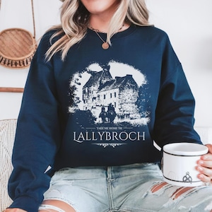 May include: A navy blue sweatshirt with a white graphic of a castle and the text "Take me home to Lallybroch".