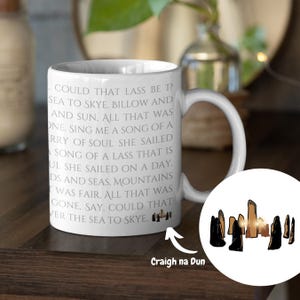May include: White ceramic mug with a quote from the book "Outlander" by Diana Gabaldon. The quote reads: "Could that lass be 1? Sea to Skye. Billow and and sun, all that was one. Sing me a song of a rry of soul she sailed a song of a lass that is ul she sailed on a day. Ds and seas, mountains was fair. All that was gone, say, could that ver the sea to Skye." The mug also features a small image of Craigh na Dun, a fictional location from the book.