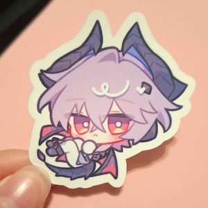 May include: A sticker featuring a chibi anime character with lavender hair, red eyes, and dark purple horns and wings. The character is holding a small white object. The sticker has a white border and is set against a pink background.