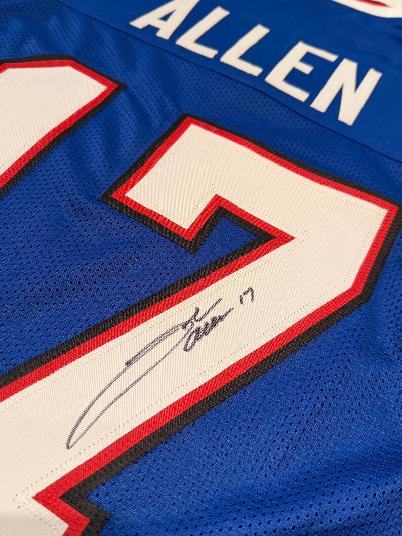 Puede incluir: Una camiseta de malla azul con el nombre "ALLEN" en letras blancas en la parte superior. El n&uacute;mero "17" se muestra prominentemente en blanco con ribetes rojos y negros. Se puede ver una firma en la camiseta.