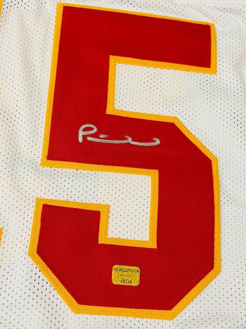 Puede incluir: Una camiseta deportiva de malla blanca con un n&uacute;mero cinco grande de color rojo y borde amarillo. El n&uacute;mero incluye una firma plateada en el centro y una pegatina de autenticaci&oacute;n dorada rectangular en la parte inferior con el texto GOLDENCERTS.COM.