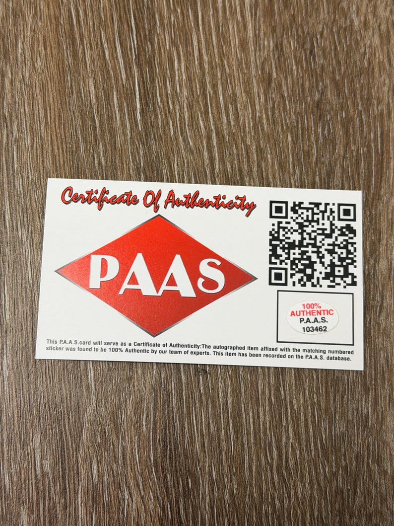 May include: A white Certificate of Authenticity card with red accents. The card features the text "Certificate Of Authenticity" and the PAAS logo. Includes a QR code and the text "100% AUTHENTIC P.A.A.S. 103462".