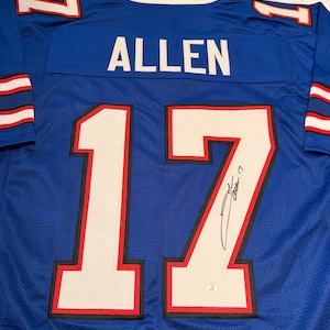 Puede incluir: Una camiseta de malla azul con el nombre "ALLEN" en la espalda y el n&uacute;mero "17" en blanco con ribete rojo. La camiseta tiene una firma en el n&uacute;mero 17. La camiseta tiene rayas blancas y rojas en las mangas.