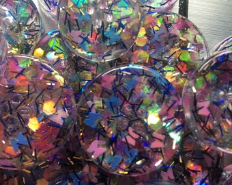 Boutons uniques fait de résine epoxy avec insertion de paillettes holographiques et papillons pastels.