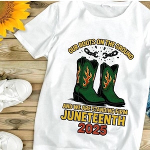 May include: White t-shirt with a graphic featuring green cowboy boots with orange flames, the text "OUR BOOTS ON THE GROUND" and "JUNETEENTH 2025". The shirt is next to sunflowers and white sneakers.