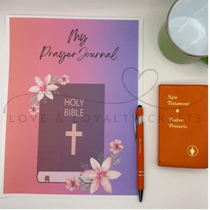 May include: A prayer journal with the text "My Prayer Journal" and a floral design, a pen, and a small orange book with the text "New Testament Psalms Proverbs". The journal has a purple and pink gradient background.