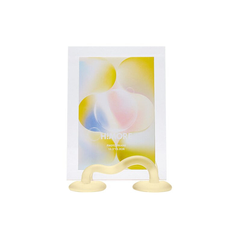 May include: A yellow plastic photo frame stand with a clear glass photo frame. The photo frame is 10.2" x 13.3 cm and has a yellow and pink abstract design.