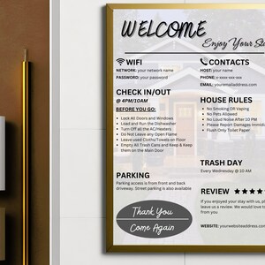 以下が含まれることがあります： WiFi、チェックイン/チェックアウト時間、ハウスルール、ゴミの日、駐車場、レビューセクションに関する情報が記載された、ゲスト向けのウェルカムサイン。サインは金色のフレームと白い背景に黒いテキストで書かれています。