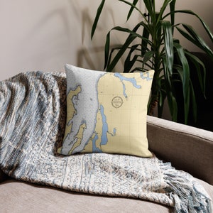May include: A decorative throw pillow with a nautical map design. The pillow features a light blue and yellow color scheme with a compass rose in the center. The compass rose has the text "Let's Go North" inside.