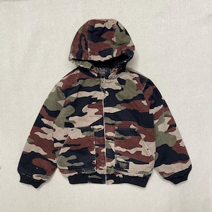 May include: A camouflage jacket with a hood, zip fastening, and two front pockets. The jacket features a pattern of brown, green, black, and tan shapes. The jacket has a black ribbed hem and cuffs. The brand name "Walls" is visible.