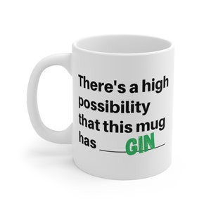 May include: White ceramic mug with a curved handle. The mug features the text "There's a high possibility that this mug has __ GIN" in black, with "GIN" in green. A humorous gift idea for gin lovers.