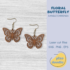 May include: Two brown wooden butterfly dangle earrings with intricate cut-out designs. The earrings are suspended from gold-colored hooks. The image also includes the text "FLORAL BUTTERFLY DANGLE EARRINGS" and "Laser cut files SVG . PNG . EPS".