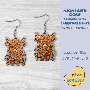 May include: Wooden dangle earrings featuring a Highland cow design tangled with Christmas lights. The earrings are laser cut and have a light brown wood grain appearance. The text on the image reads "HIGHLAND COW TANGLED WITH CHRISTMAS LIGHTS DANGLE EARRINGS".