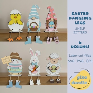 Könnte beinhalten: Sechs Holzfiguren für Ostern mit hängenden Beinen, darunter ein Küken, ein Zwerg und ein Hase. Die Figuren sind in leuchtenden Farben bemalt. Der Text lautet "Easter Dangling Legs" und "Shelf Sitters".