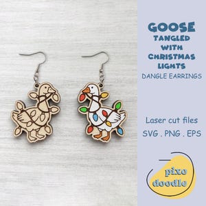 May include: A pair of dangle earrings featuring a goose tangled in Christmas lights. One earring is a natural wood finish, while the other is colored white with orange feet and beak, and multi-colored light bulbs in red, blue, green, and yellow.