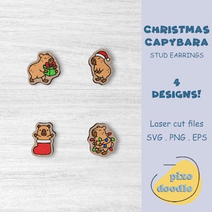 Op de afbeelding: Houten oorstekers met capybara-ontwerpen voor Kerstmis. De oorbellen tonen capybara's met een cadeau, een kerstmuts, een kous en kerstverlichting. De tekst op de afbeelding luidt "CHRISTMAS CAPYBARA STUD EARRINGS 4 DESIGNS!" en "Laser cut files SVG.PNG.EPS".